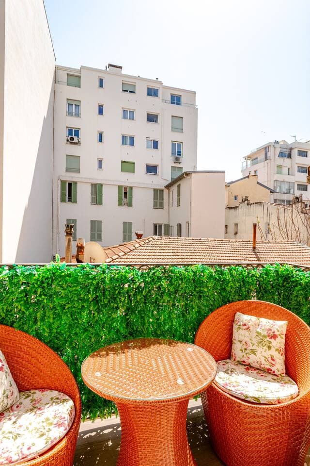 Balcon meublé de fauteuils et d'une table en résine tressée orange