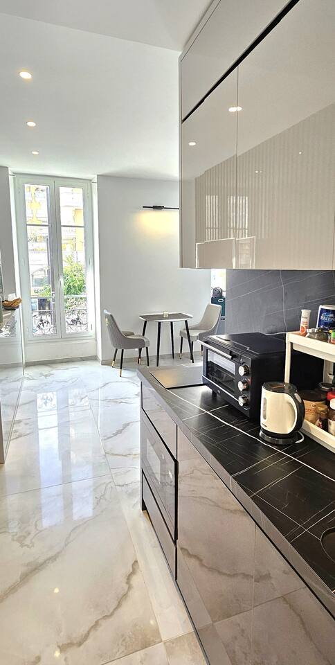 Equipped kitchen with pale marble worktop and dining corner