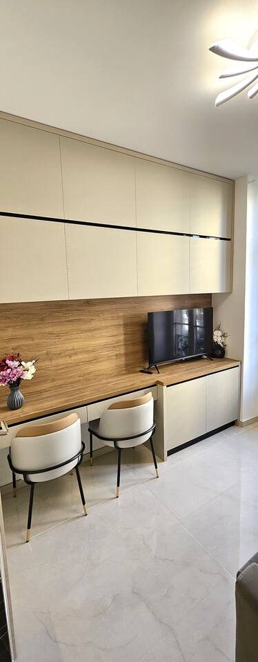 Studio kitchen corner with coffee machine, stools and wooden splashback